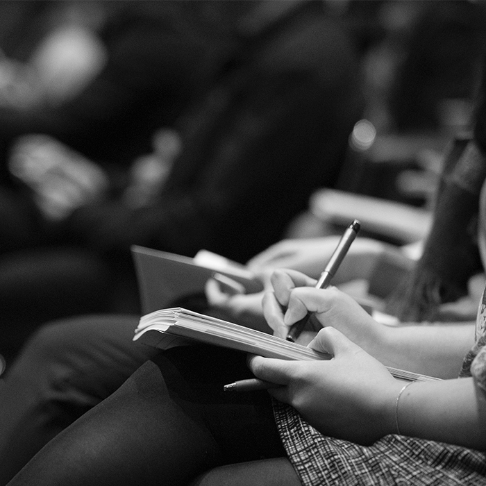 Foto em preto e branco mostra pessoas assistindo palestra, representando participação no NUPPAA