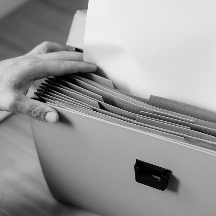 Foto em preto e branco mostra pessoa mexendo em arquivo